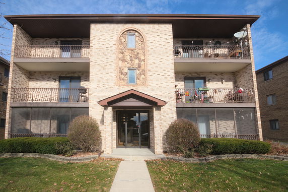 Front view of a three-story apartment building with balconies.