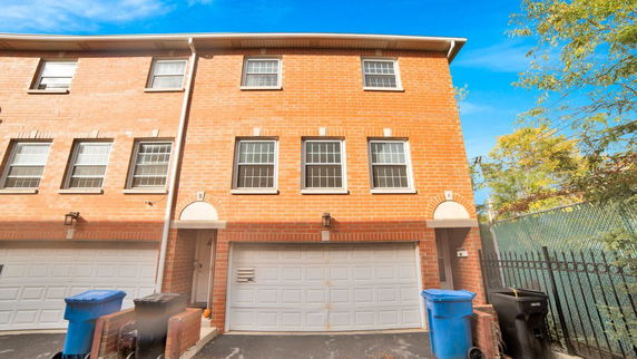 Front view of a multi-story brick house with a double garage.