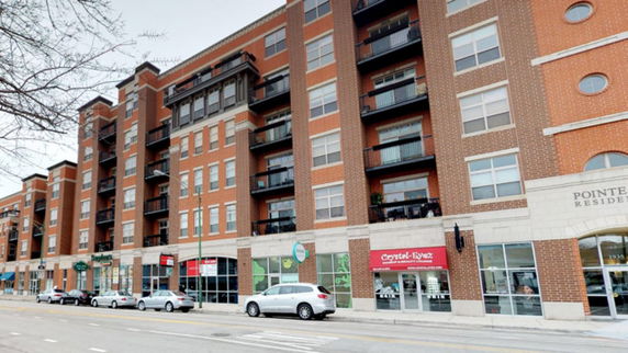 Front view of a multi-story residential and commercial building.