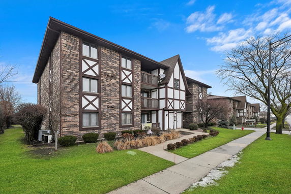 Front view of a multi-story brick building with decorative wood elements.