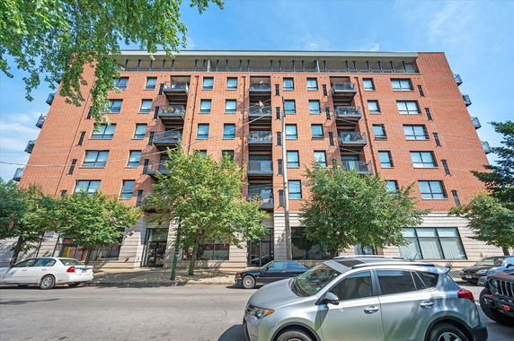 Front view of a multi-story brick building with balconies.