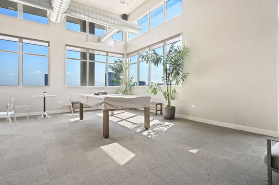 Modern indoor recreational area with covered pool table and seating.