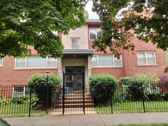 Front view of a two-story brick building with a small entrance.