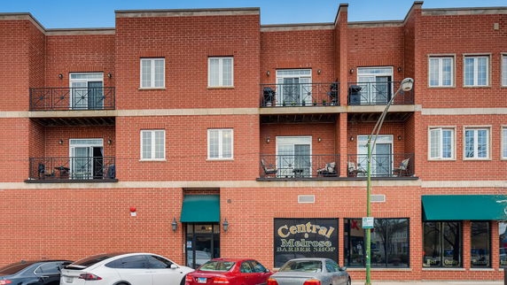 Front view of a multi-story brick building with balconies.