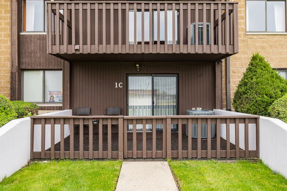 Front view of a multi-story building with balconies and sliding glass doors.
