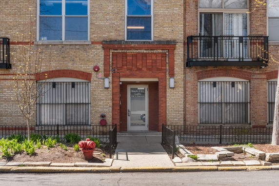 Front view of a brick building with iron railings and a balcony.