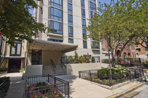 Front view of a multi-story residential building with a covered entrance.