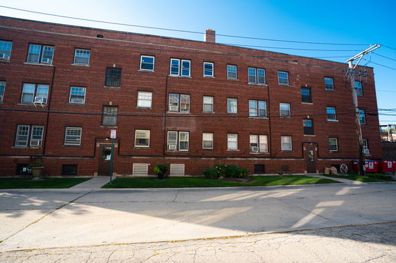 Front view of a multi-story brick building with multiple windows.