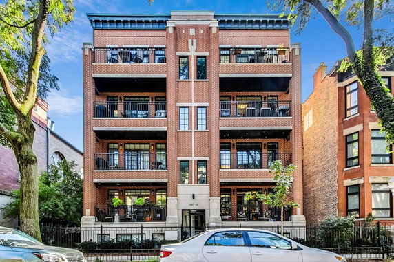Front view of a multi-story brick building with balconies.