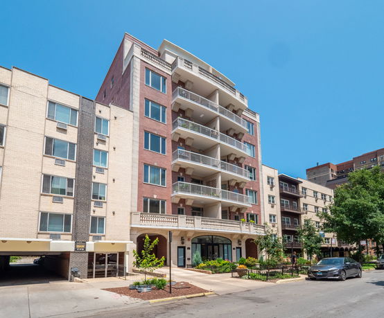 Front view of a multi-story apartment building with balconies.