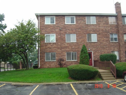 Front view of a multi-story brick apartment building.
