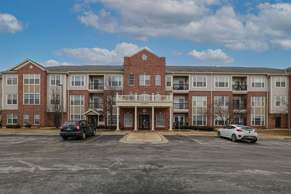 Front view of a multi-story residential building with several entrances and balconies.
