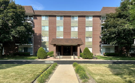 Front view of a multi-story brick building with a central entrance.