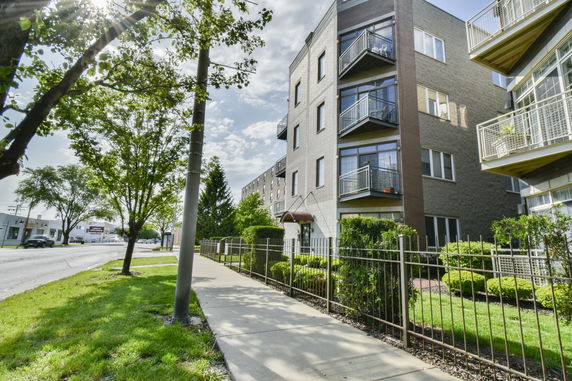 Front view of a multi-story apartment building with balconies.