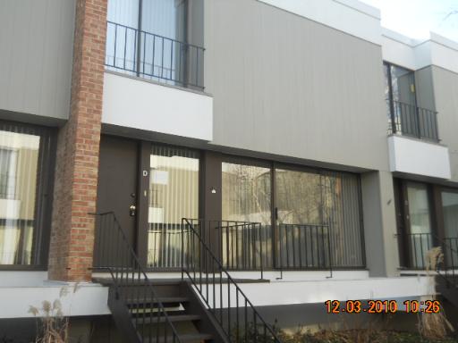Front view of a multi-story building with large windows and balconies.