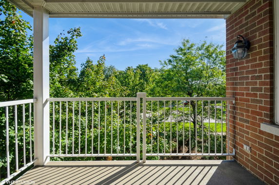 View from a balcony with railing and surrounding trees.