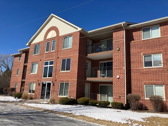 Front view of a three-story brick apartment building.