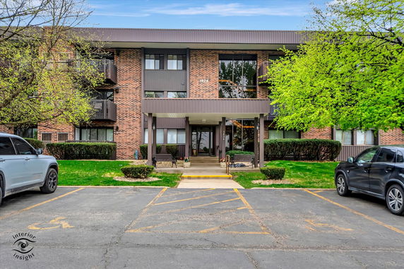Front view of a three-story brick apartment building with a central entrance.