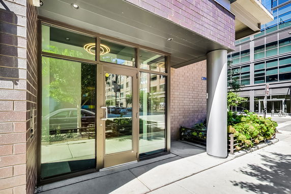Entrance of a modern building with glass doors and brick exterior.