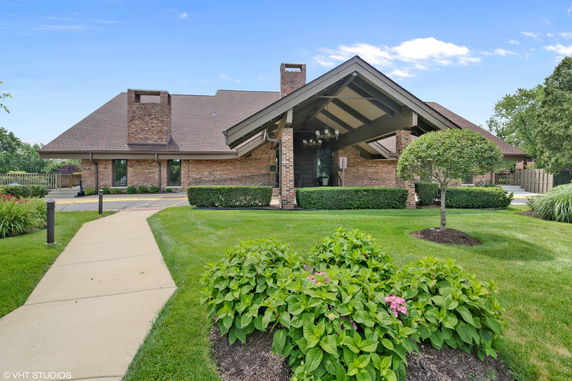 Front view of a brick house with a pitched roof and covered entrance.