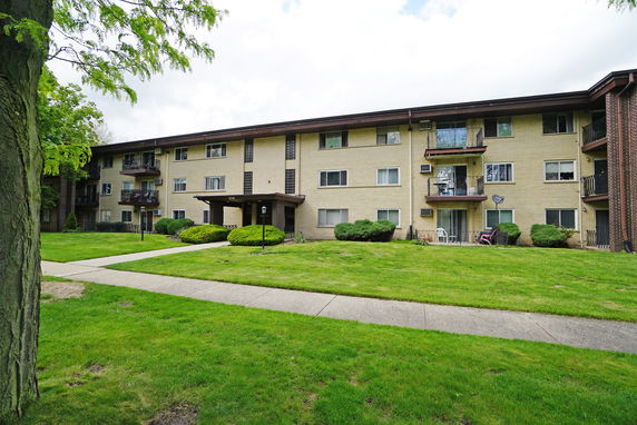Front view of a three-story apartment building with balconies.