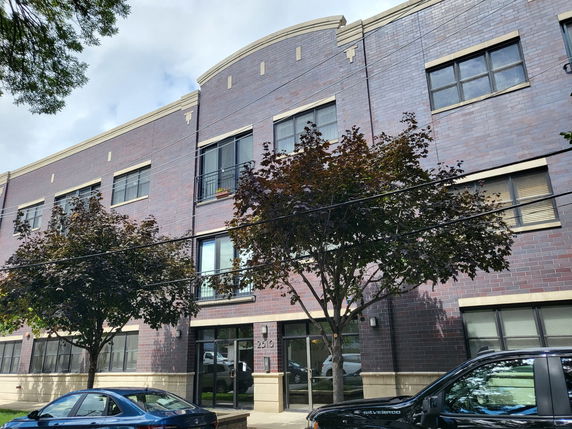 Front view of a three-story building with brick facade and multiple windows.
