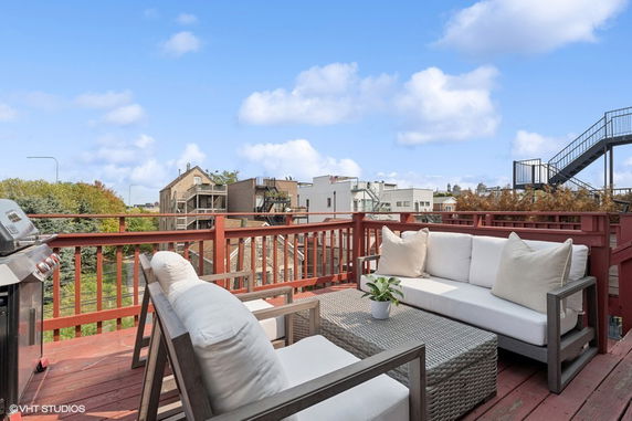 Rooftop area with outdoor seating and a barbecue grill.
