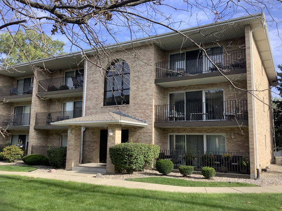 Front view of a three-story apartment building with balconies.