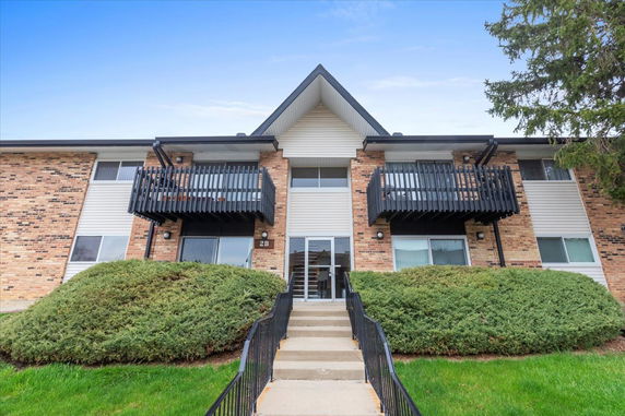 Front view of a two-story apartment building with balconies.
