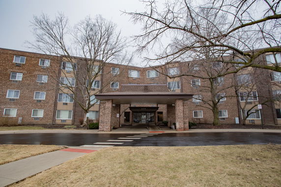 Front view of a multi-story brick building with an entrance canopy.
