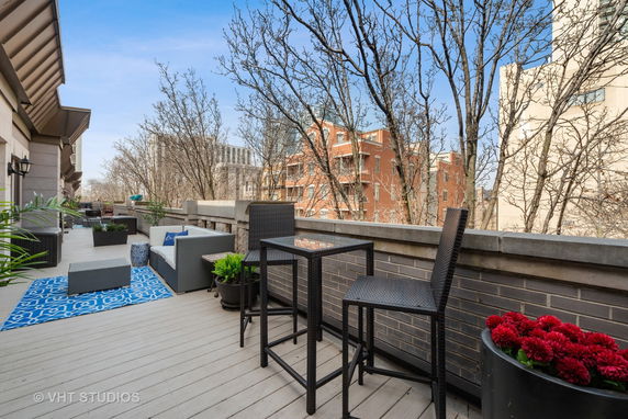 Rooftop deck with outdoor seating and views of surrounding buildings.