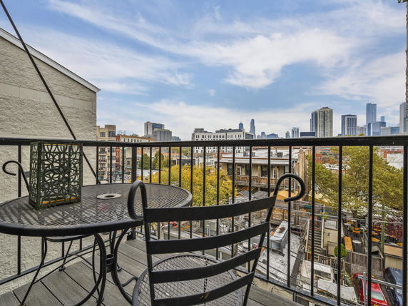 View from a balcony overlooking a cityscape with tall buildings in the background.