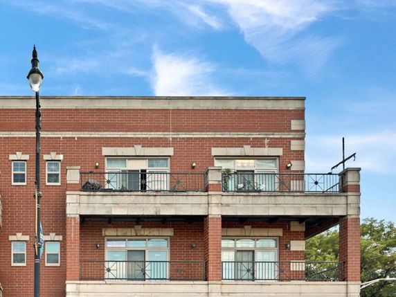 Front view of a multi-story brick building with balconies.