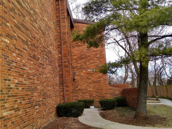 Front view of a brick building with a visible number on the wall.