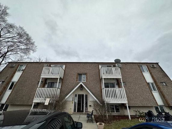 Front view of a multi-story apartment building with balconies.
