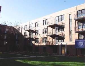 Front view of a multi-story apartment building with balconies.