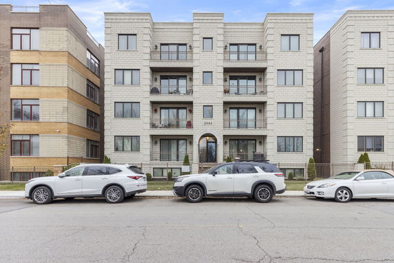 Front view of a multi-story apartment building with balconies.