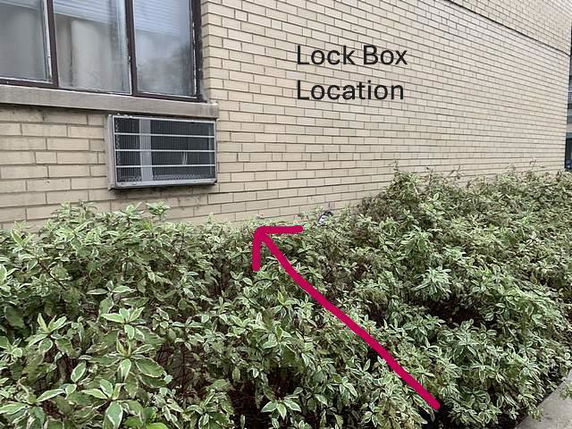 Partial view of a building wall with windows and an air conditioning unit.