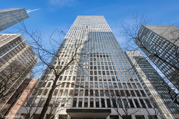 Front view of a tall high-rise building against a clear blue sky.