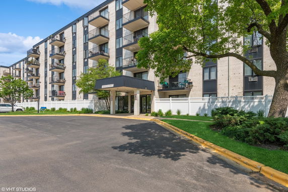 Front view of a multi-story apartment building with balconies.