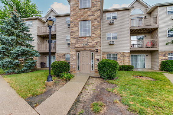 Front view of a three-story apartment building with balconies and entrance.