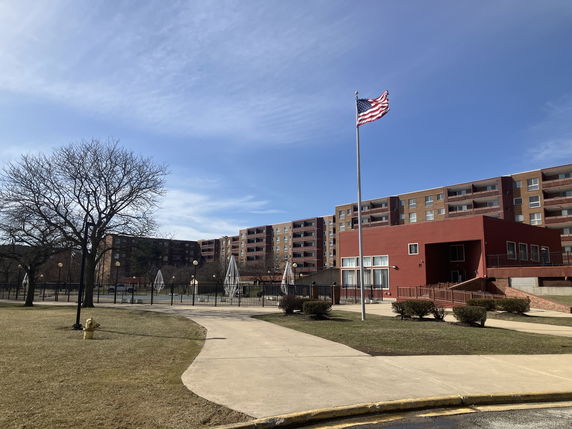 Front view of a multi-story apartment building with balconies.