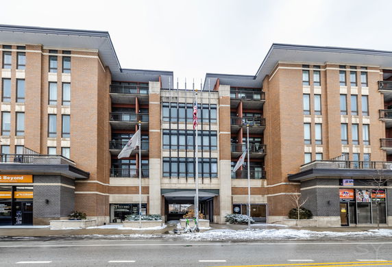 Front view of a multi-story building with brick facade and balconies.