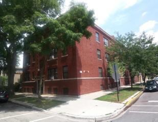 Front view of a brick apartment building with three stories.
