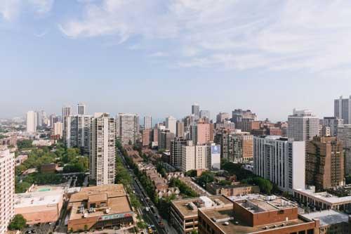 Panoramic view of a cityscape with numerous tall buildings and clear sky.