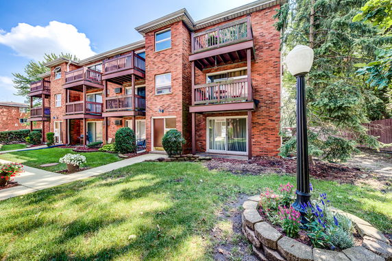 Front view of a multi-story brick apartment building with balconies.