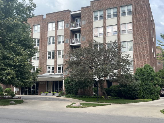 Front view of a multi-story brick apartment building.
