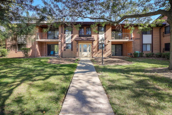 Front view of a two-story brick residential building with balconies.