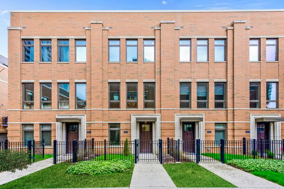 Front view of a multi-story brick house with multiple entrances.