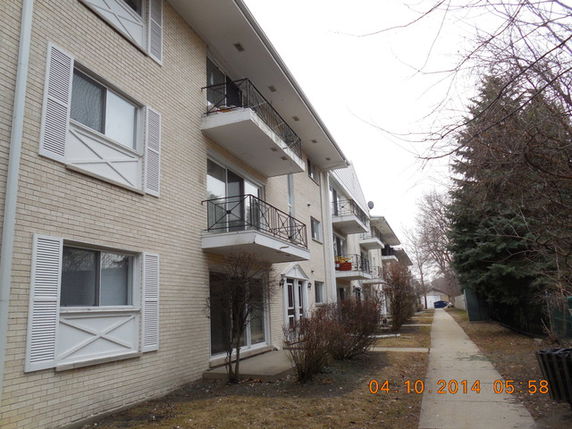 Front view of a multi-story apartment building with balconies.